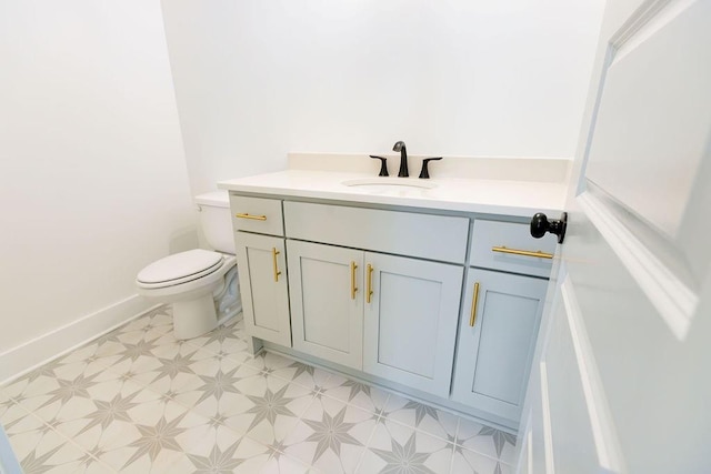 bathroom featuring toilet, tile patterned floors, baseboards, and vanity