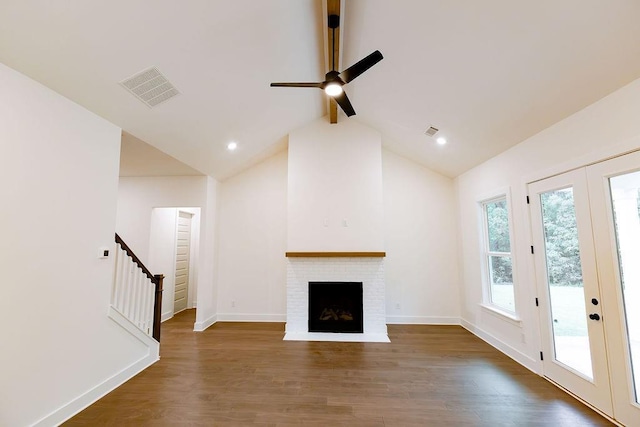 unfurnished living room featuring dark wood-style flooring, visible vents, and stairway