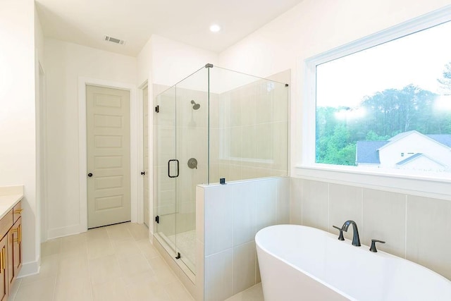 bathroom with a stall shower, visible vents, a soaking tub, tile patterned flooring, and vanity