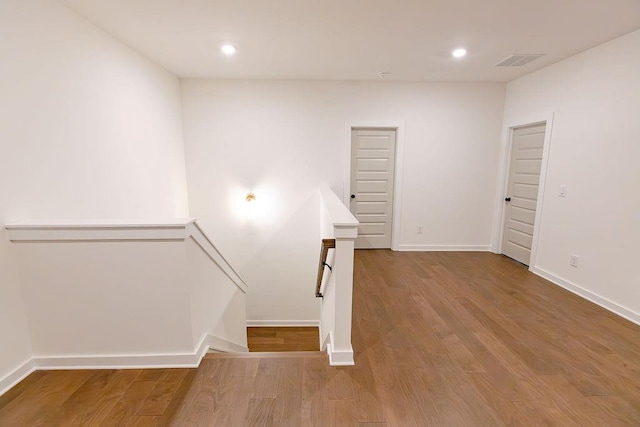 staircase featuring visible vents, wood finished floors, and recessed lighting