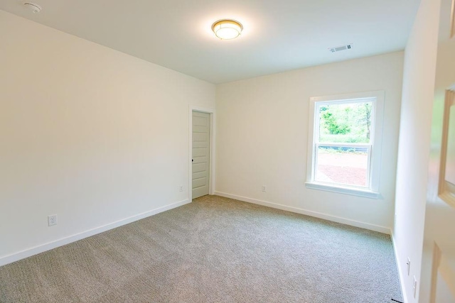 carpeted spare room with visible vents and baseboards