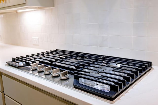 room details featuring tasteful backsplash and stainless steel gas cooktop