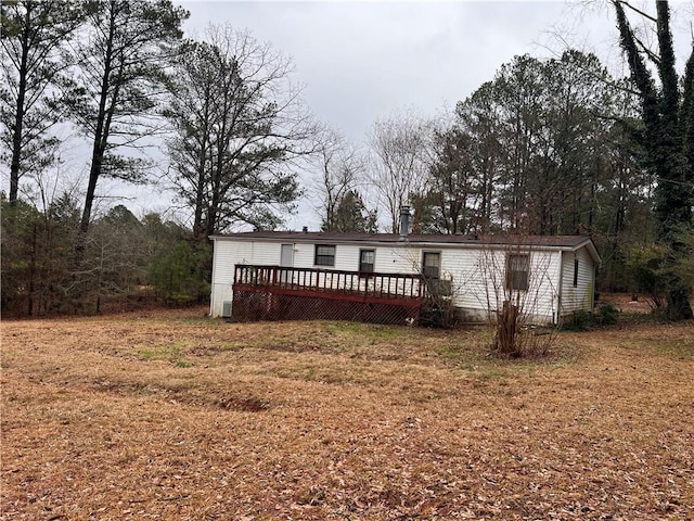 back of house with a lawn and a wooden deck