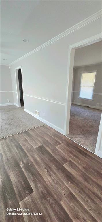 unfurnished room featuring crown molding and dark wood-type flooring