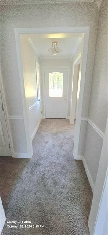 hallway featuring crown molding and light colored carpet