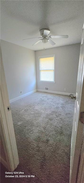 carpeted spare room with ceiling fan and a textured ceiling