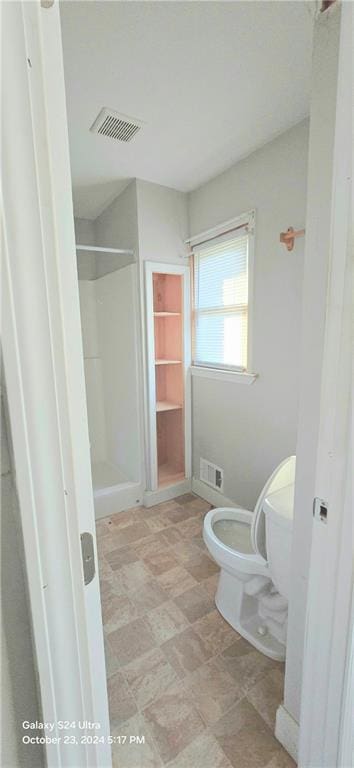 bathroom with toilet and walk in shower