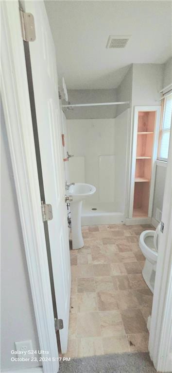 bathroom featuring toilet and a shower