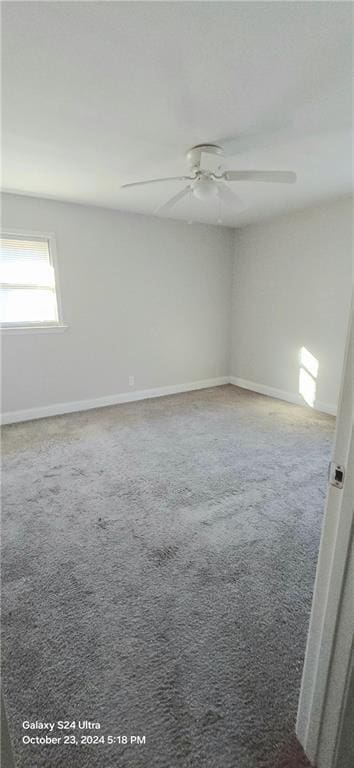 carpeted spare room with ceiling fan