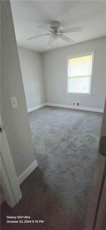 carpeted spare room with ceiling fan