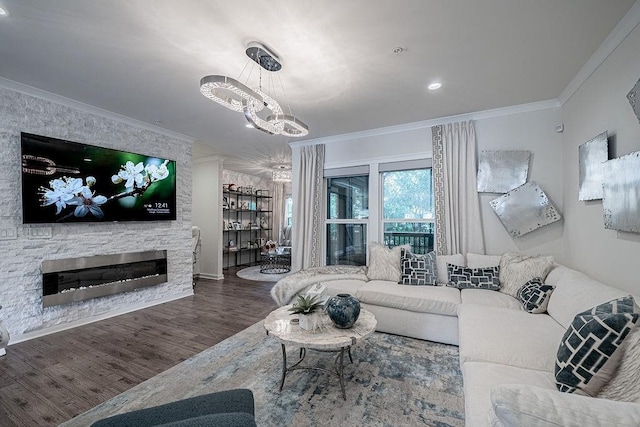 living room with a chandelier, wood finished floors, ornamental molding, and a fireplace