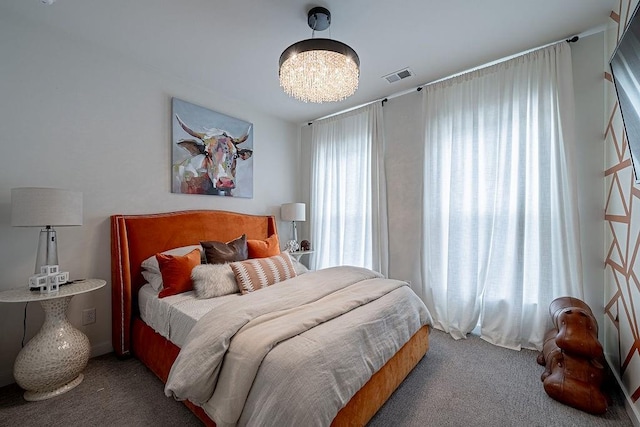 bedroom with visible vents, carpet floors, and a chandelier