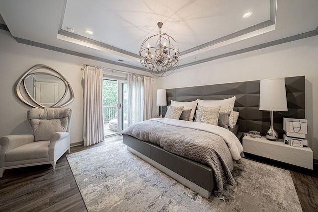 bedroom featuring a raised ceiling, access to outside, a notable chandelier, and wood finished floors