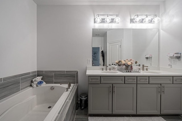 bathroom with a sink, visible vents, a garden tub, and double vanity