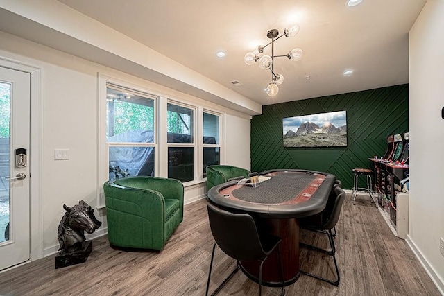 recreation room with an accent wall, wood finished floors, a healthy amount of sunlight, and baseboards