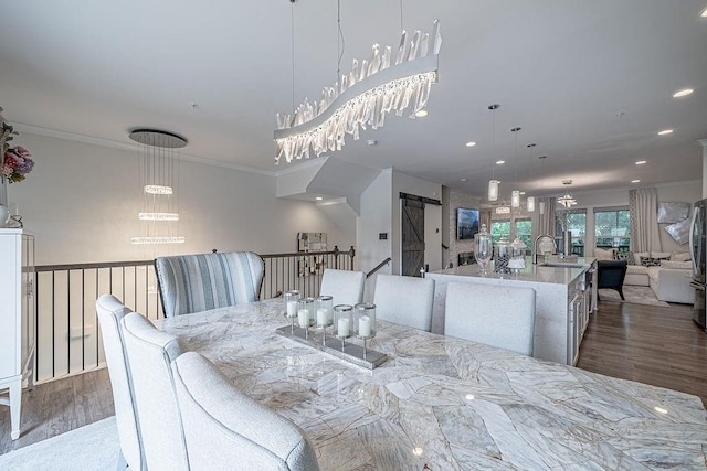 dining room with an inviting chandelier, crown molding, and wood finished floors