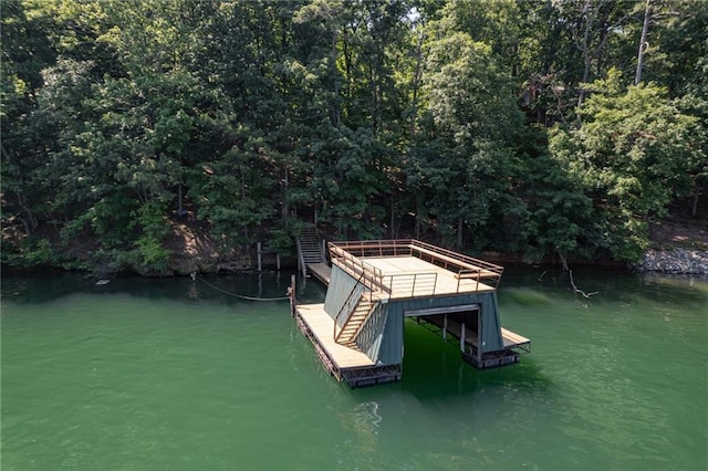 view of dock with a water view and a wooded view