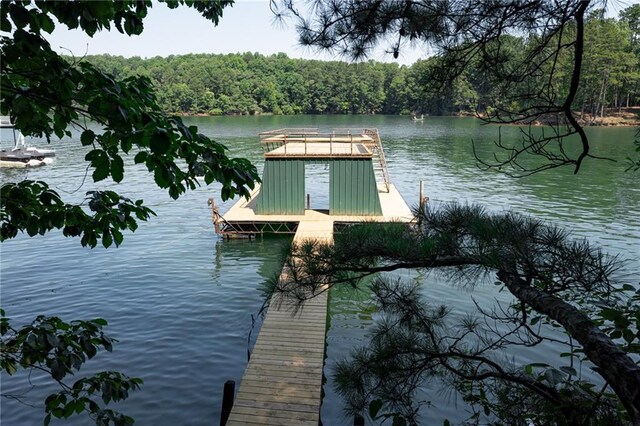 view of dock featuring a water view and a forest view