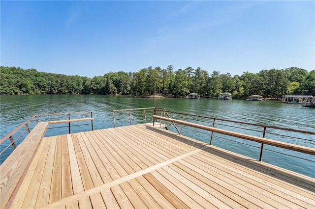 view of dock with a water view and a view of trees