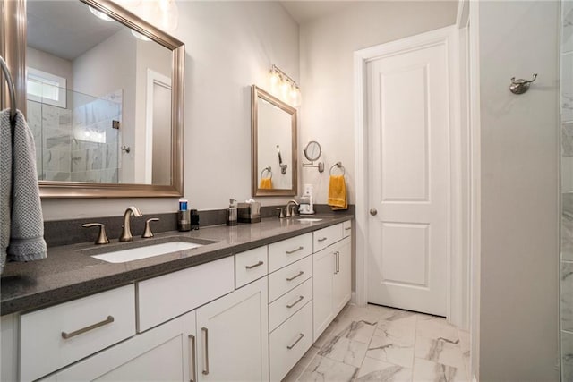 full bath with a sink, double vanity, tiled shower, and marble finish floor