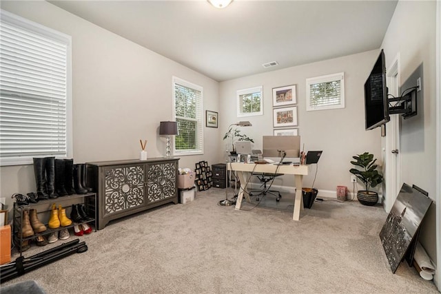 carpeted home office featuring baseboards, a wealth of natural light, and visible vents