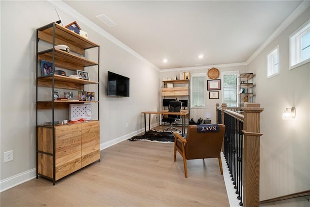 office area with baseboards, ornamental molding, light wood finished floors, and visible vents