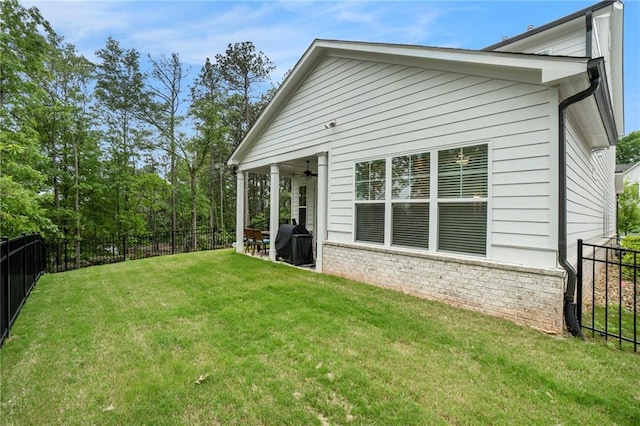 back of house featuring a fenced backyard, ceiling fan, a yard, and a patio area