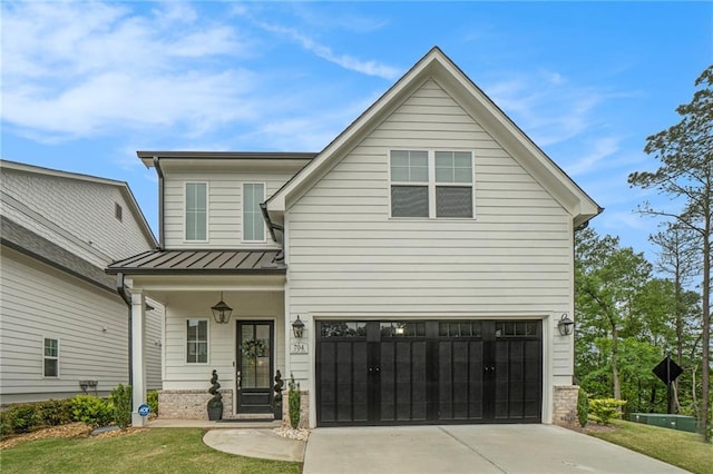traditional-style house featuring a front lawn, metal roof, a standing seam roof, concrete driveway, and an attached garage