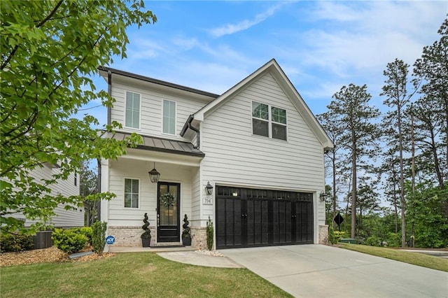 view of front of house with a front yard, a standing seam roof, brick siding, concrete driveway, and an attached garage