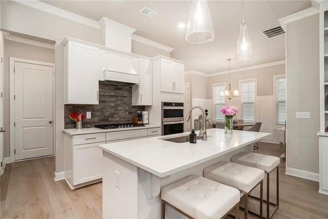 kitchen with white cabinetry, visible vents, a breakfast bar, and gas stovetop
