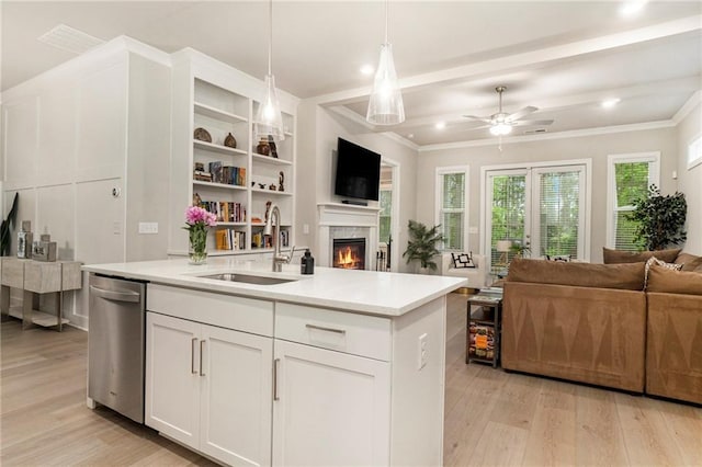 kitchen featuring open floor plan, a sink, light wood finished floors, and dishwasher