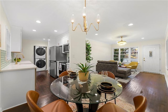 2903 Akron St, East Point, GA 30344 - dining area featuring estacked washer and dryer, dark wood-style flooring, recessed lighting, a chandelier, and ornamental molding