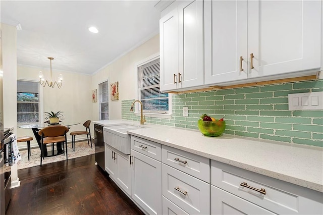 2903 Akron St, East Point, GA 30344 - kitchen featuring crown molding, dishwashing machine, dark wood-type flooring, a chandelier, and decorative backsplash