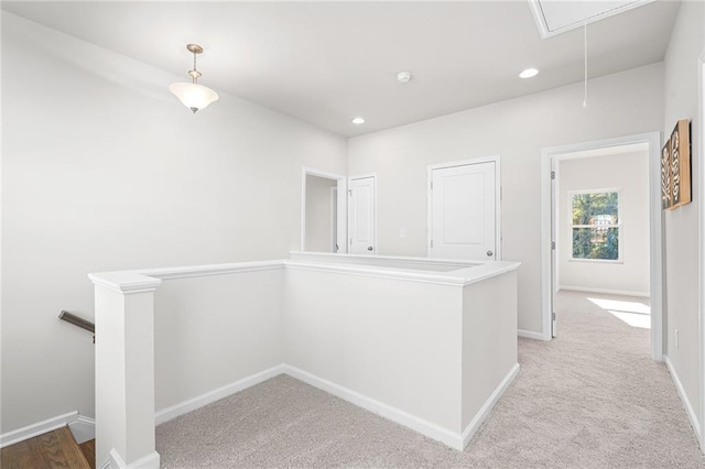 hallway featuring light colored carpet