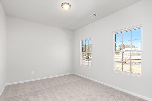 unfurnished room featuring light carpet