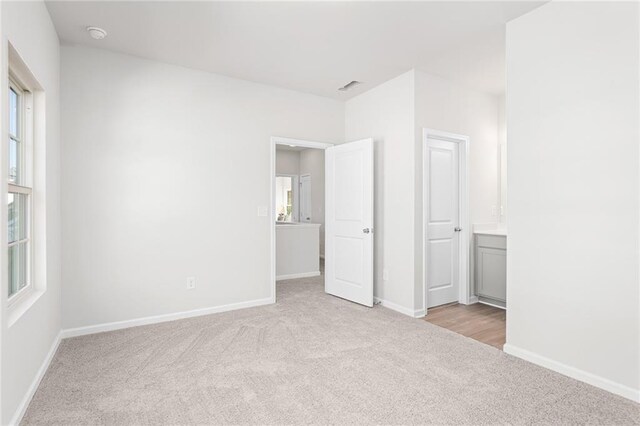 unfurnished bedroom featuring light carpet