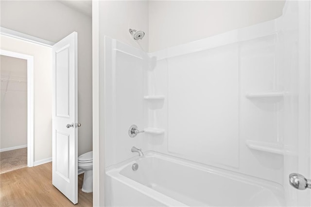 bathroom featuring hardwood / wood-style floors, toilet, and shower / washtub combination