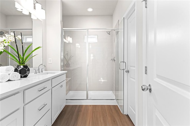 bathroom featuring vanity, wood-type flooring, and a shower with door