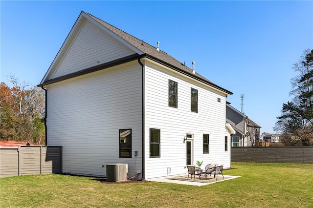 rear view of house featuring a lawn, central AC, and a patio