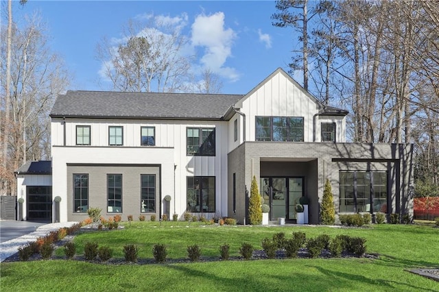 modern inspired farmhouse featuring a garage and a front lawn