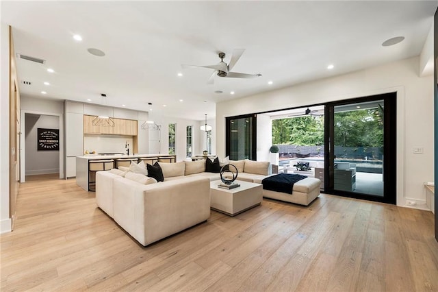 living room featuring light wood-type flooring and ceiling fan