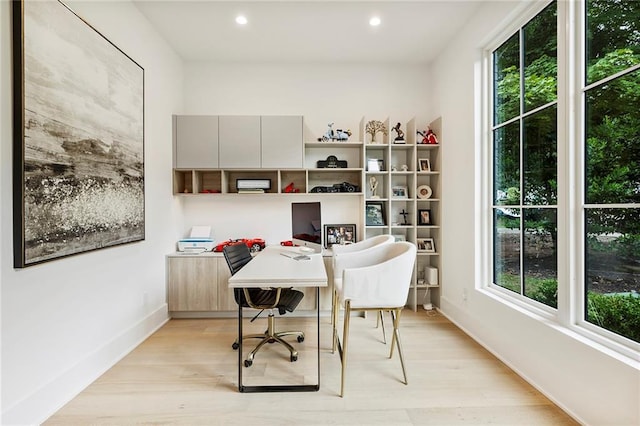 home office with light hardwood / wood-style floors