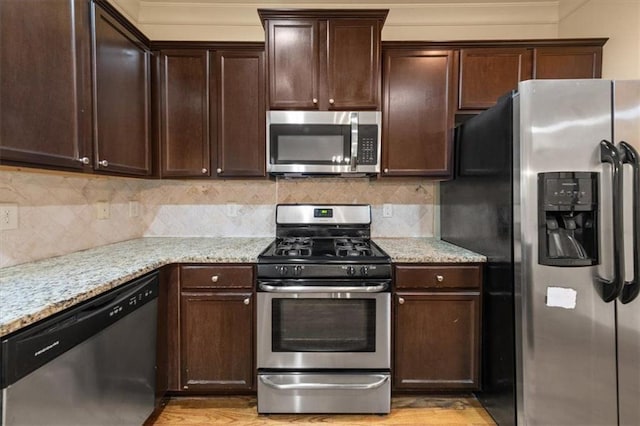 kitchen featuring backsplash, light hardwood / wood-style flooring, dark brown cabinets, light stone counters, and stainless steel appliances