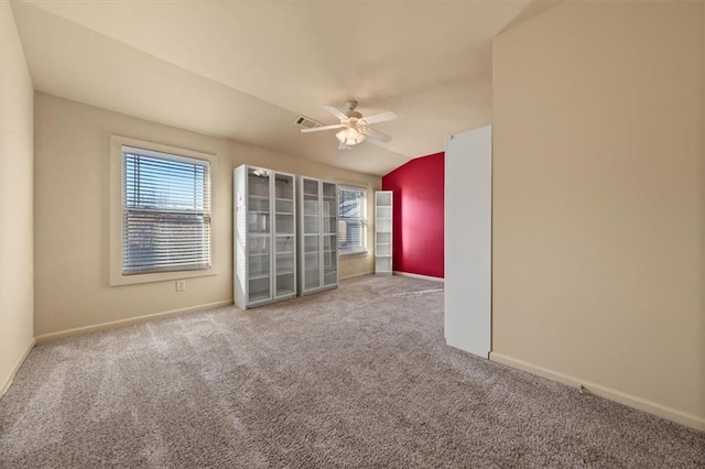 carpeted spare room with ceiling fan and vaulted ceiling