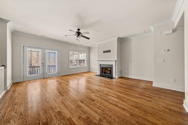 unfurnished living room with a fireplace with flush hearth, baseboards, wood finished floors, and a ceiling fan