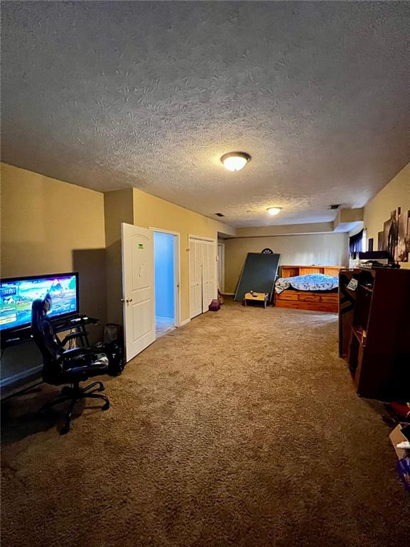 bedroom with carpet floors and a textured ceiling