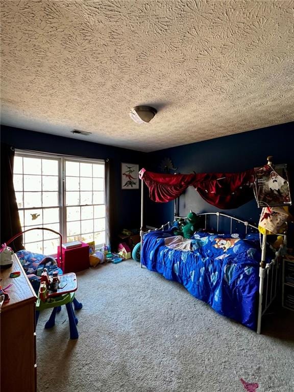 bedroom with carpet floors and a textured ceiling