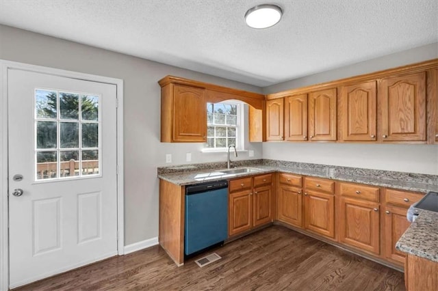 kitchen with dishwashing machine, dark wood-style flooring, a sink, visible vents, and brown cabinetry