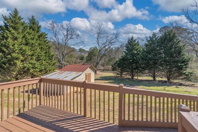 wooden terrace featuring an outbuilding and a yard