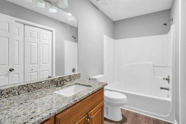 bathroom featuring visible vents, toilet, shower / tub combination, wood finished floors, and vanity